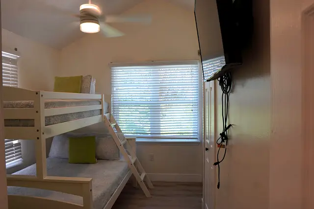 Bunk bedroom at villa 5012 with a television and a window beside the beds
