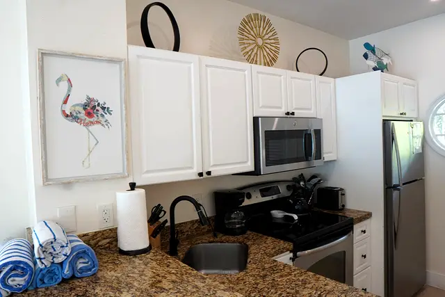 Kitchen at villa 5012 with granite counters, a full-size cooker, microwave and fridge