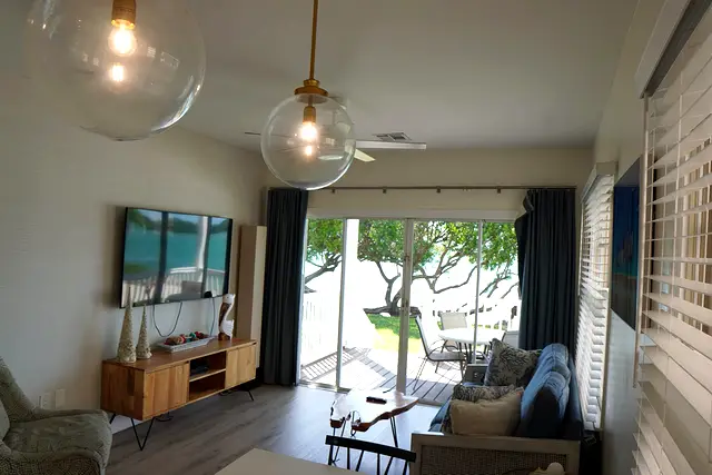 Living area at villa 5012 with sliding doors open onto the covered porch, looking out to the water