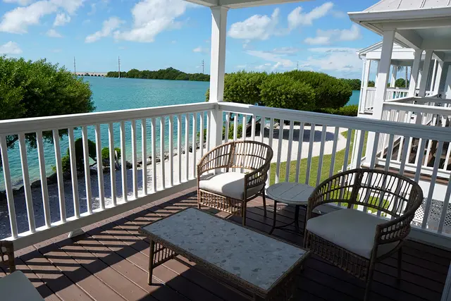 Covered porch at villa 5012 with a table and chairs, looking over the water