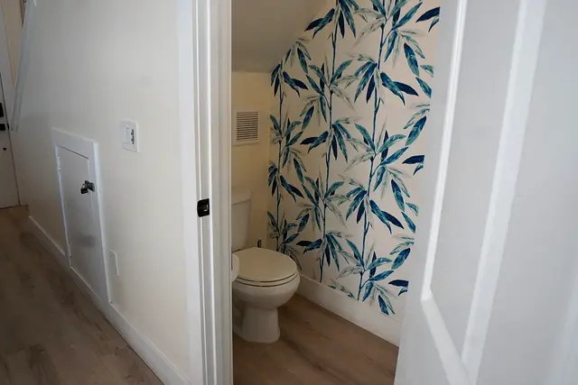 Half bathroom at villa 5012 with leaf-patterned wallpaper