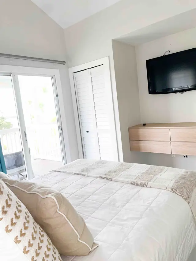 Bedroom at villa 5092 with a balcony door and a wall-mounted television