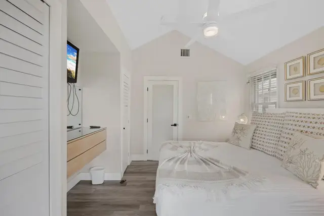 Bedroom at villa 5092 with a wall-mounted television and a ceiling fan
