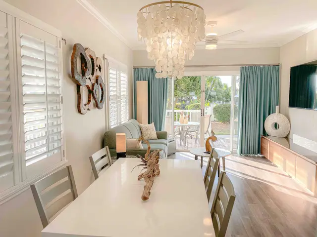 Dining table and living area at villa 5092, with shuttered windows