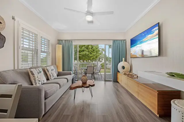 Living room at villa 5092 with a large television and doors to the porch